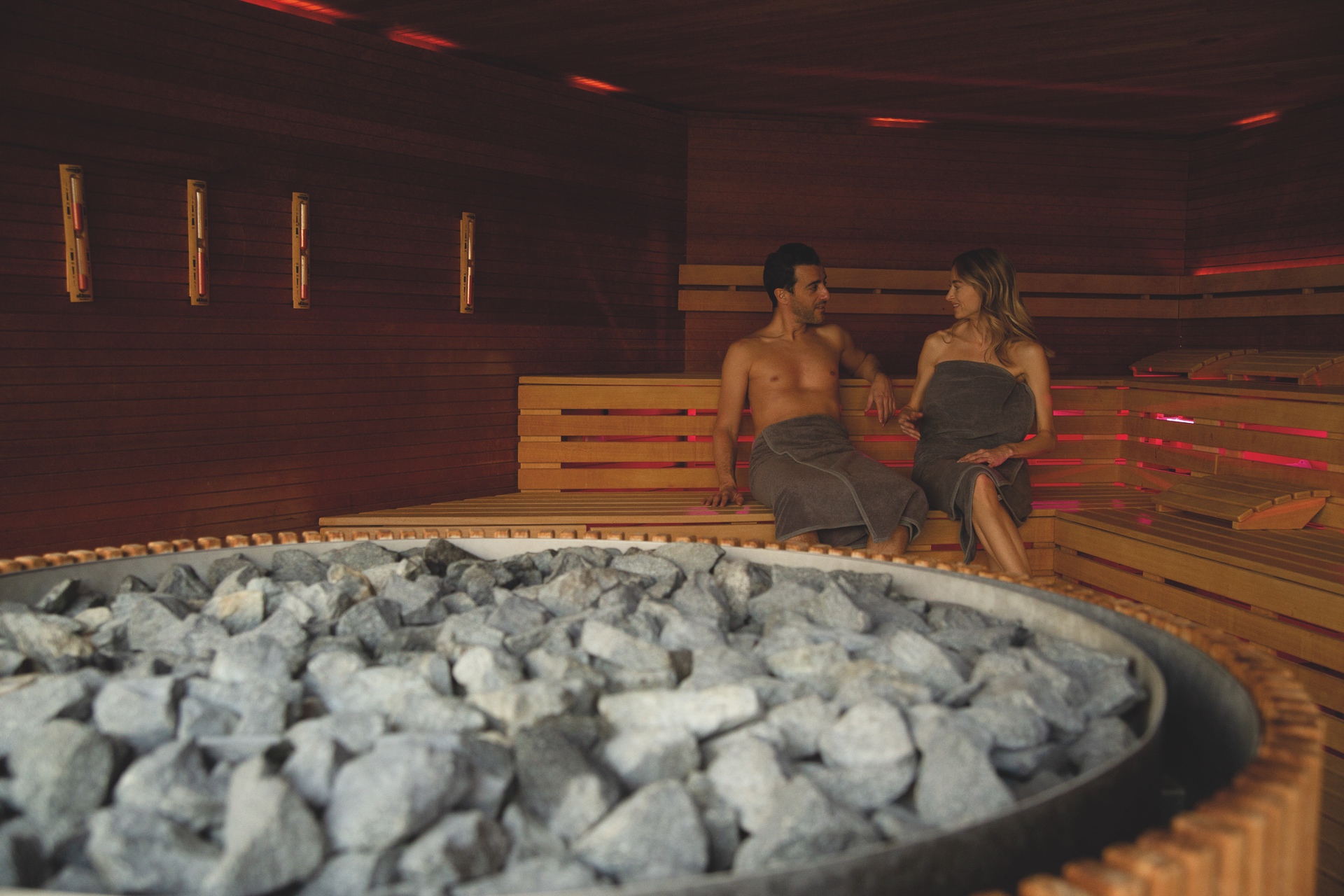 vital:werk ein Mann und eine Frau sitzen auf einer Bank in einer Sauna